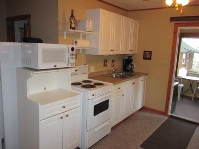 Kitchen with refrigerator/freezer, oven/stove, and microwave.